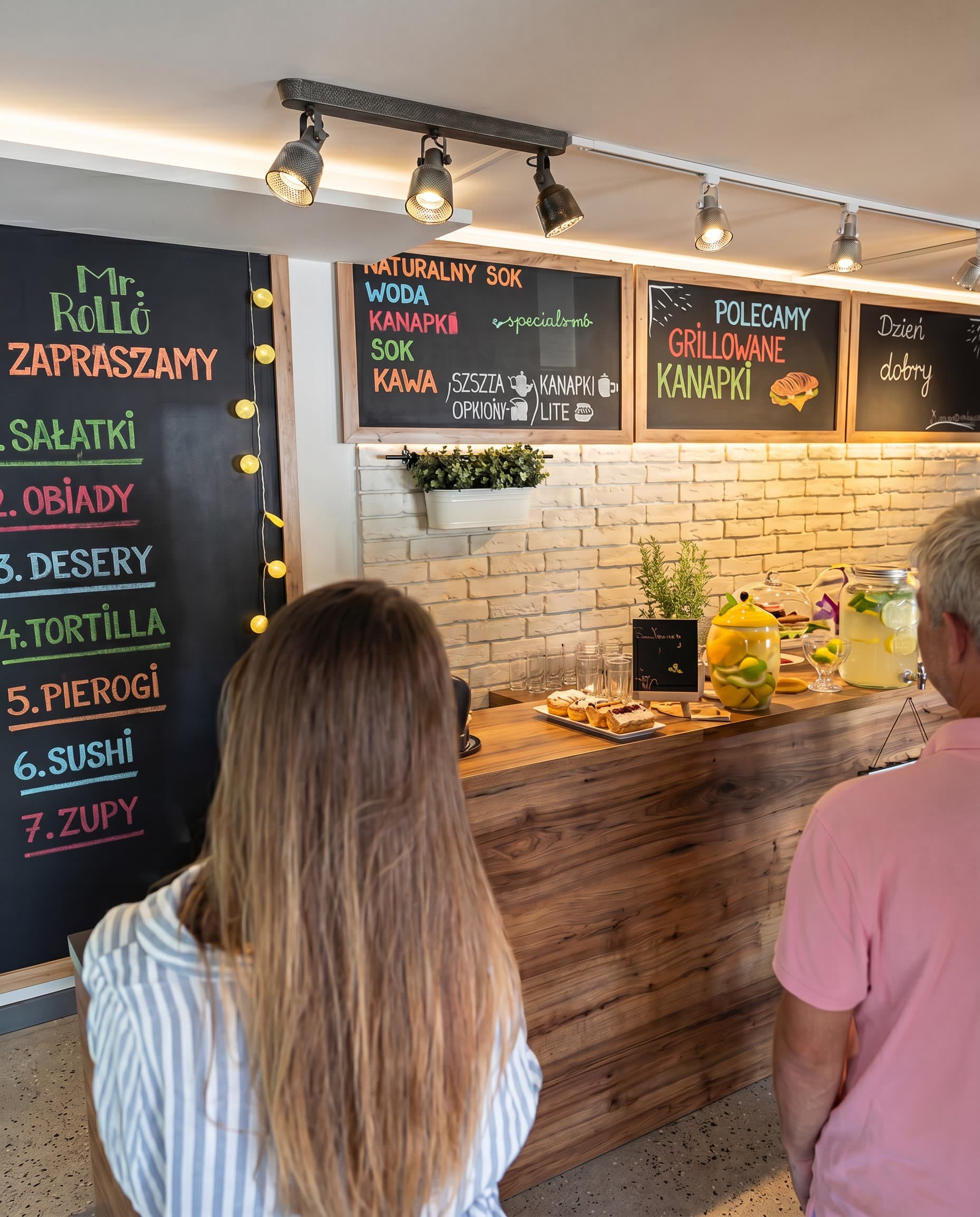 Wnętrze Bistro Mr. Rollo - lada i tablice z menu: sałatki, obiady, desery, pierogi, zupy
